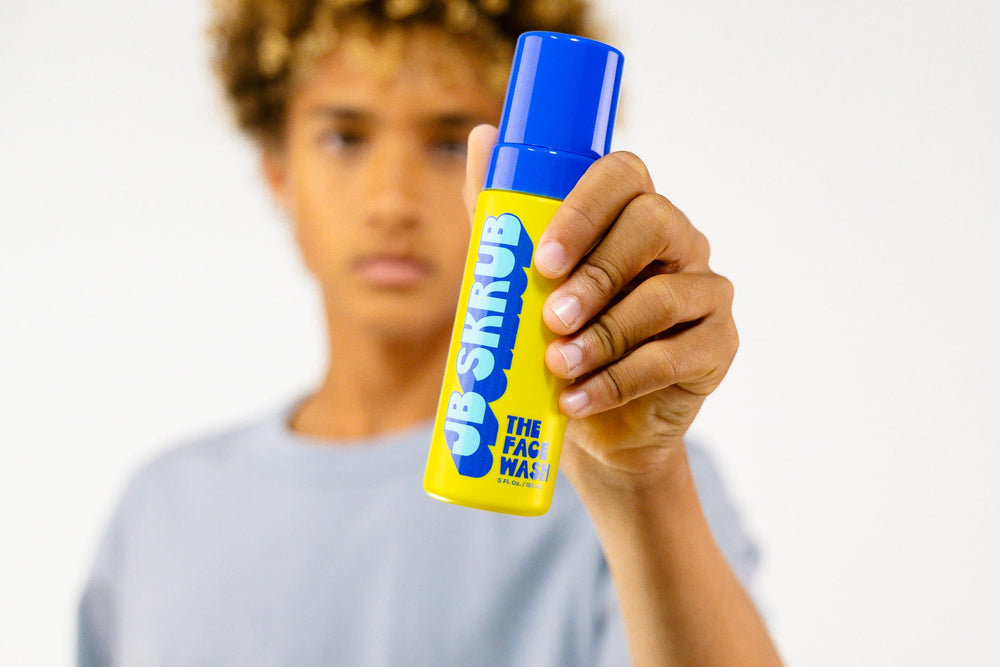 Teen boy holding JB SKRUB Face Wash