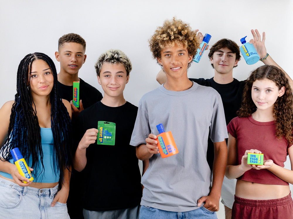 Teenagers holding JB SKRUB skincare products