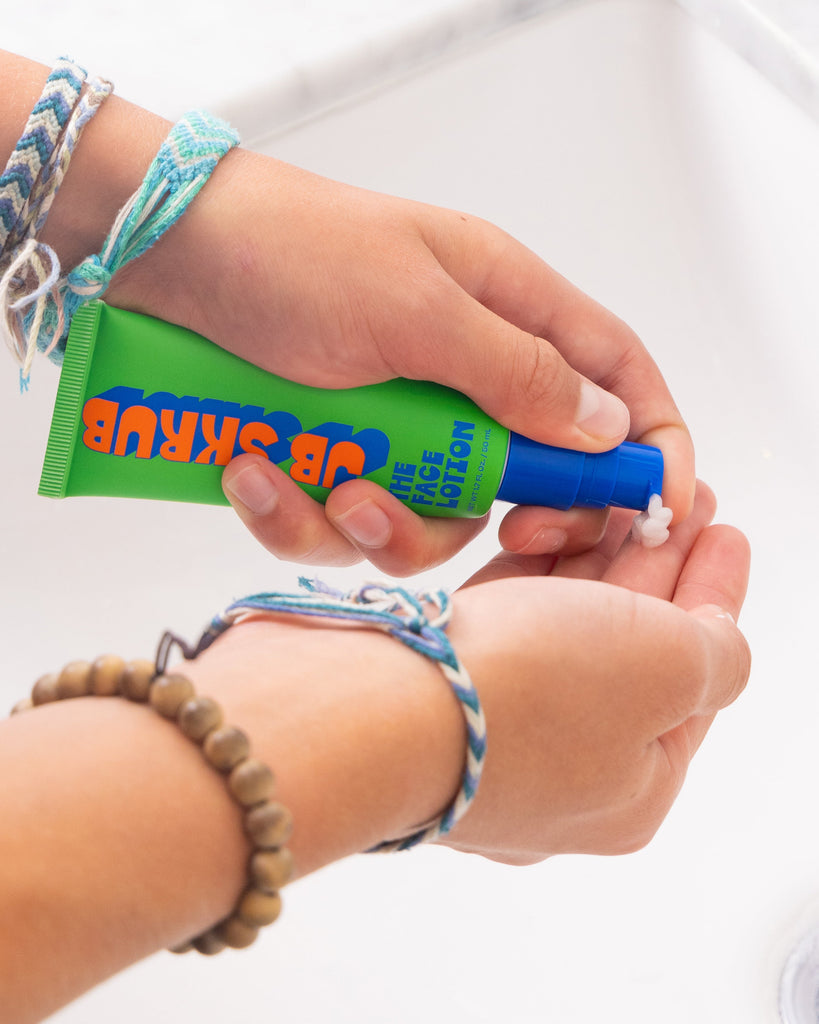 Boy putting face lotion on his hands