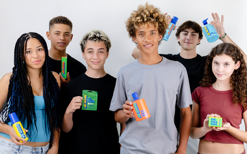 Group of young people holding various products against a white background
